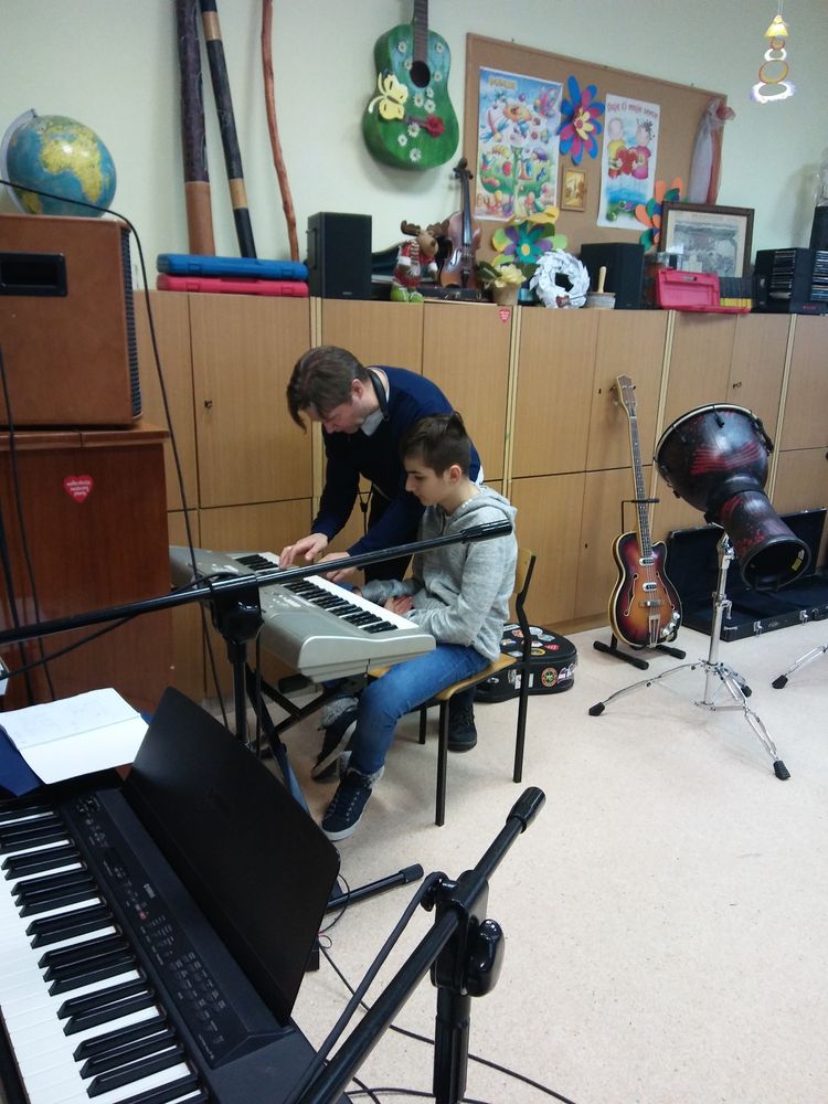 mężczyzna uczy chłopca grać na instrumencie